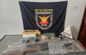 A polícia percebe as armas, drogas e cordão de ouro em operação com 40 agentes na polícia MG