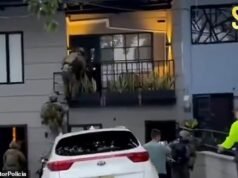 No mesmo momento, “dois membros da máfia irlandesa procurados na Grã-Bretanha” foram detidos pela polícia colombiana fortemente armada – com um suspeito vestido de pijama a segurar o seu animal de estimação Pomeranian.