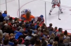 Fã de hóquei olhando para jogadores da primeira fila no jogo do Rangers