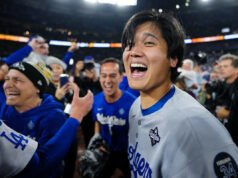 Depois de ganhar seu segundo prêmio consecutivo de MVP da NL, Shohei Ohtani se inclina para beijar seu cachorro Decoy