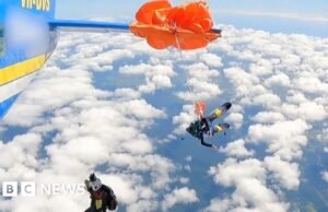 Momento em que pára-quedas de paraquedista envolve avião