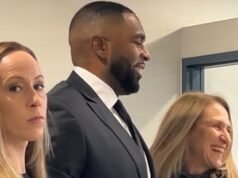 Sharon Moore sorri antes de comparecer ao tribunal, com a esposa ao seu lado